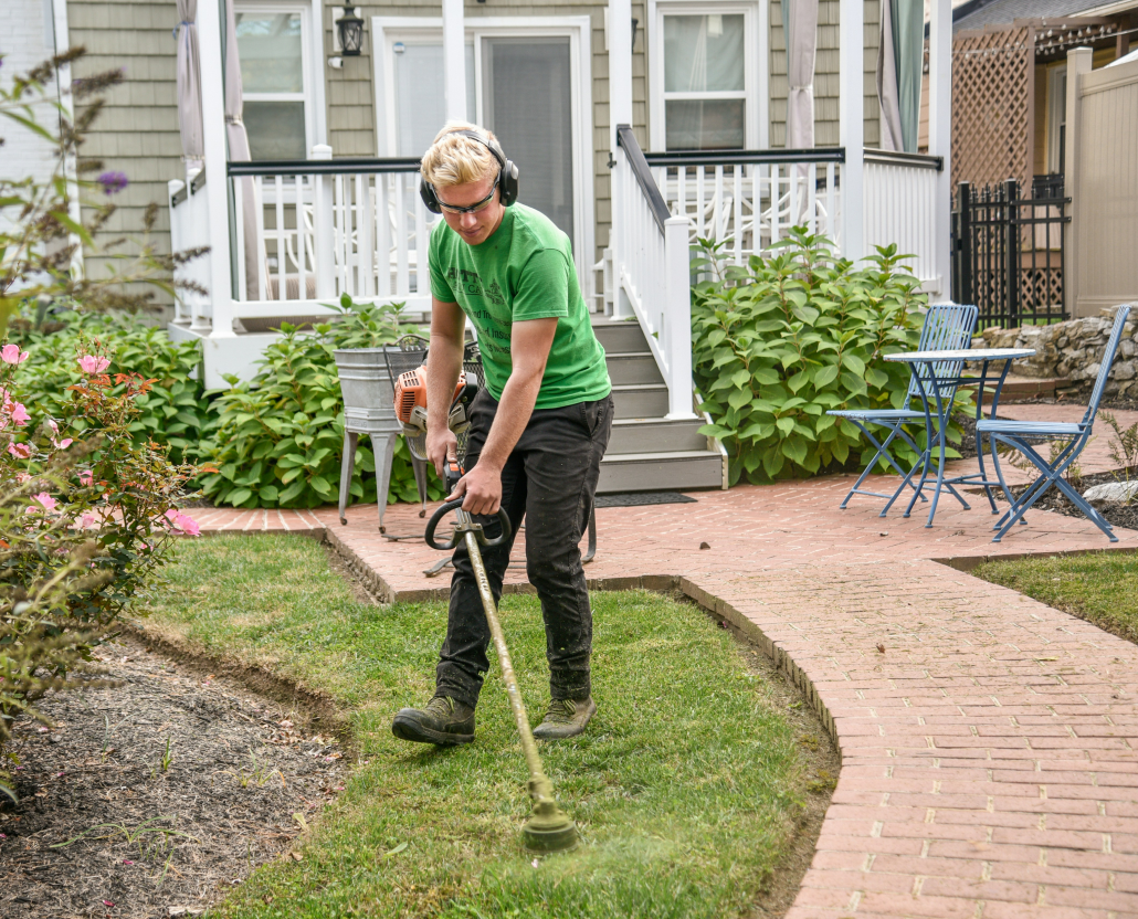 epmloyee weed eating grass